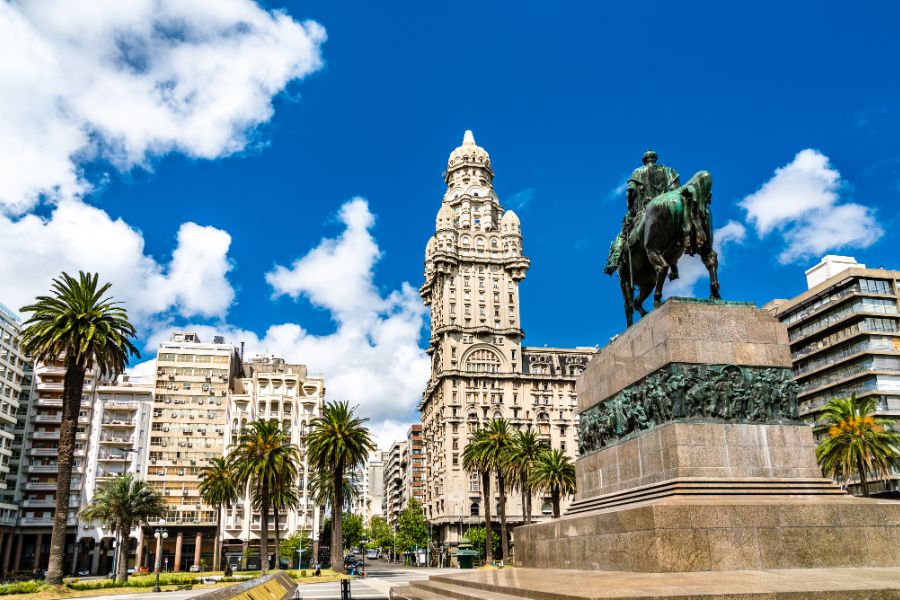 Image of Uruguay surrounded by buildings in the city centre and a statue 