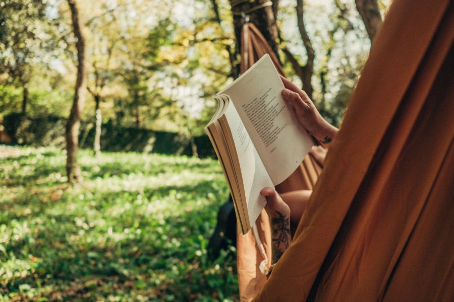 Someone reading a book in a hammock